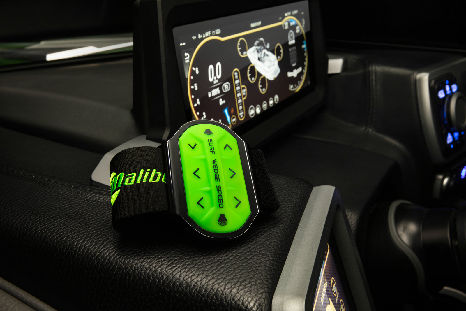 Green Malibu handheld surf-system remote on a boat's dashboard