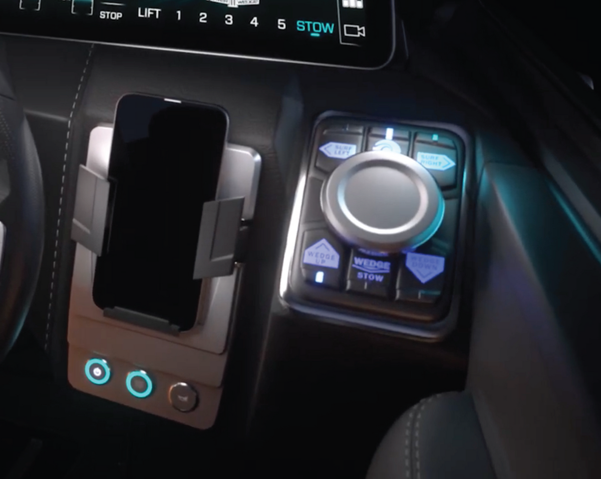 Boat dashboard touchscreen and rotary surf-system controls illuminated at night