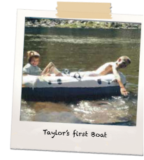 Vintage snapshot of two kids in an inflatable raft, captioned "Taylor's first Boat"