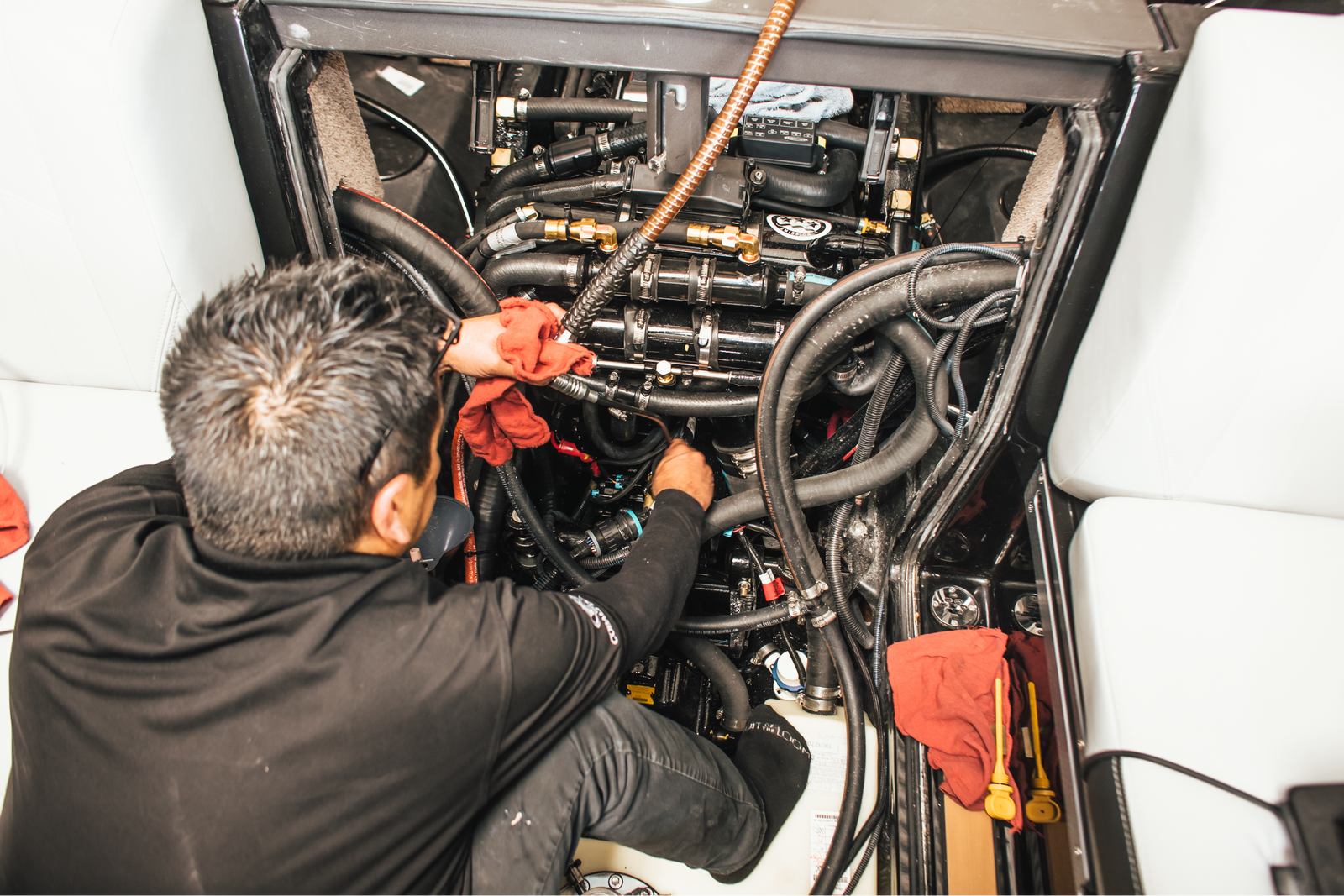 Technician servicing a boat engine bay with tools