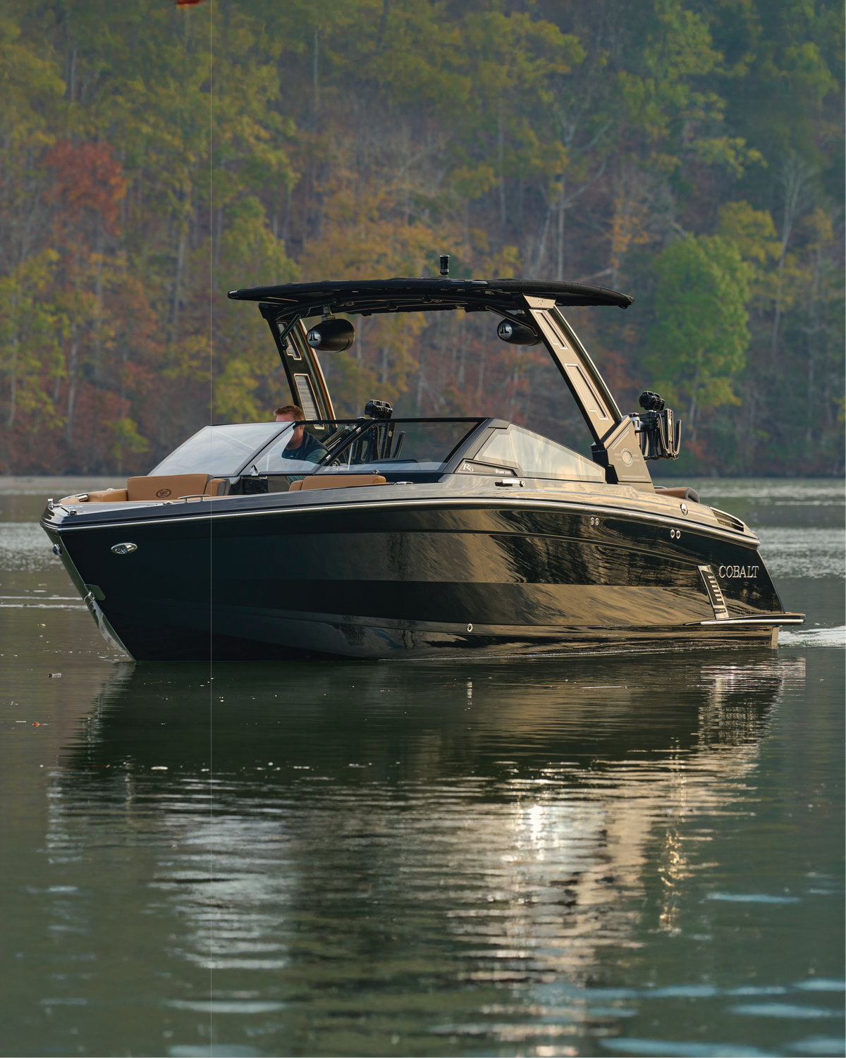 Black Cobalt bowrider boat with tower on a calm autumn lake