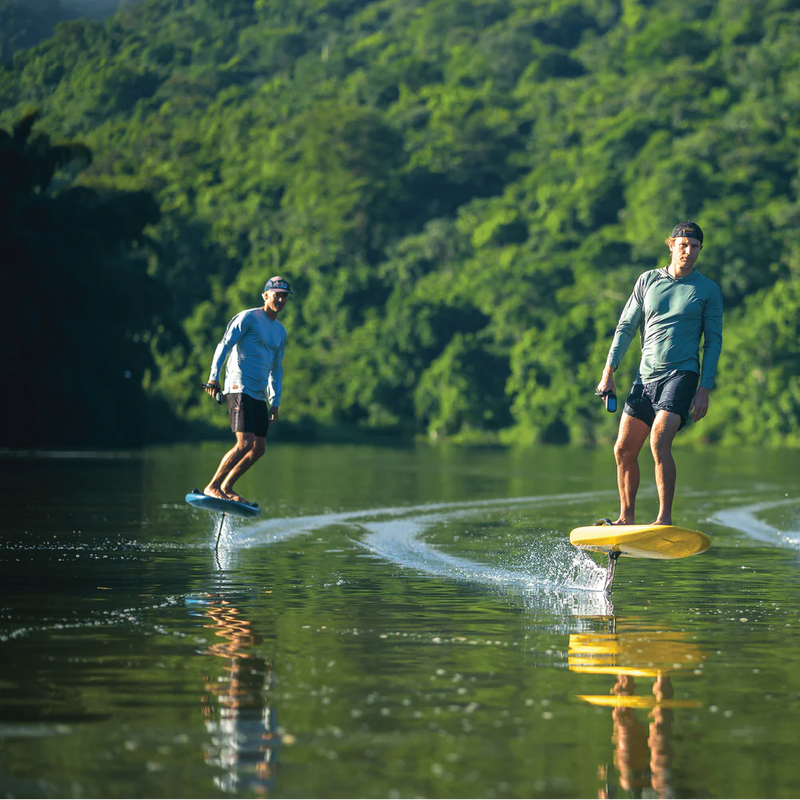 Two riders cruising on electric hydrofoil e-foils across calm water