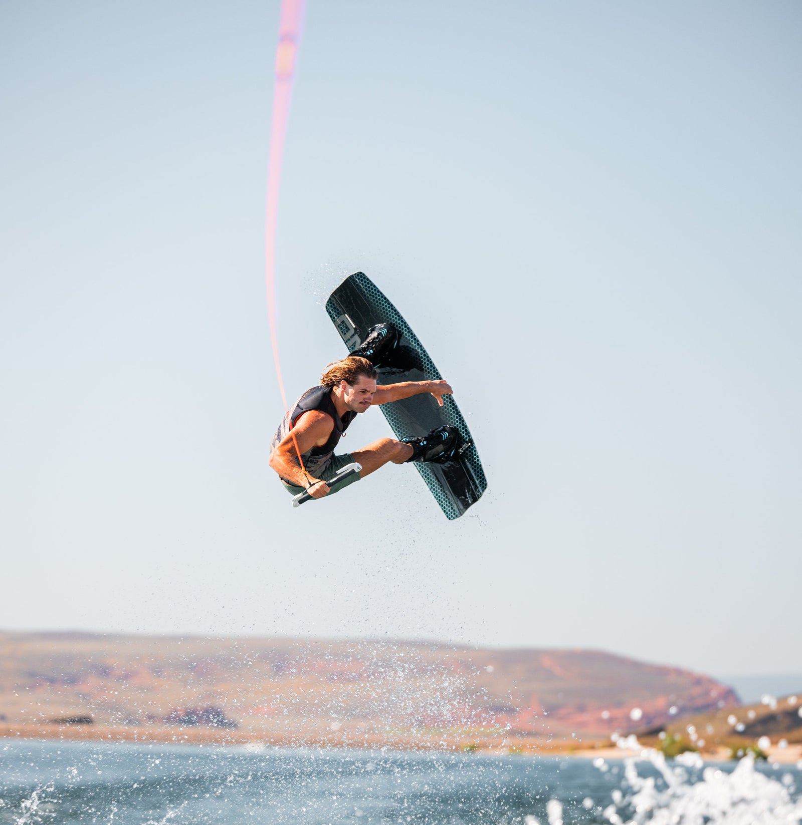 Wakeboarder launching high off the wake with the handle line taut